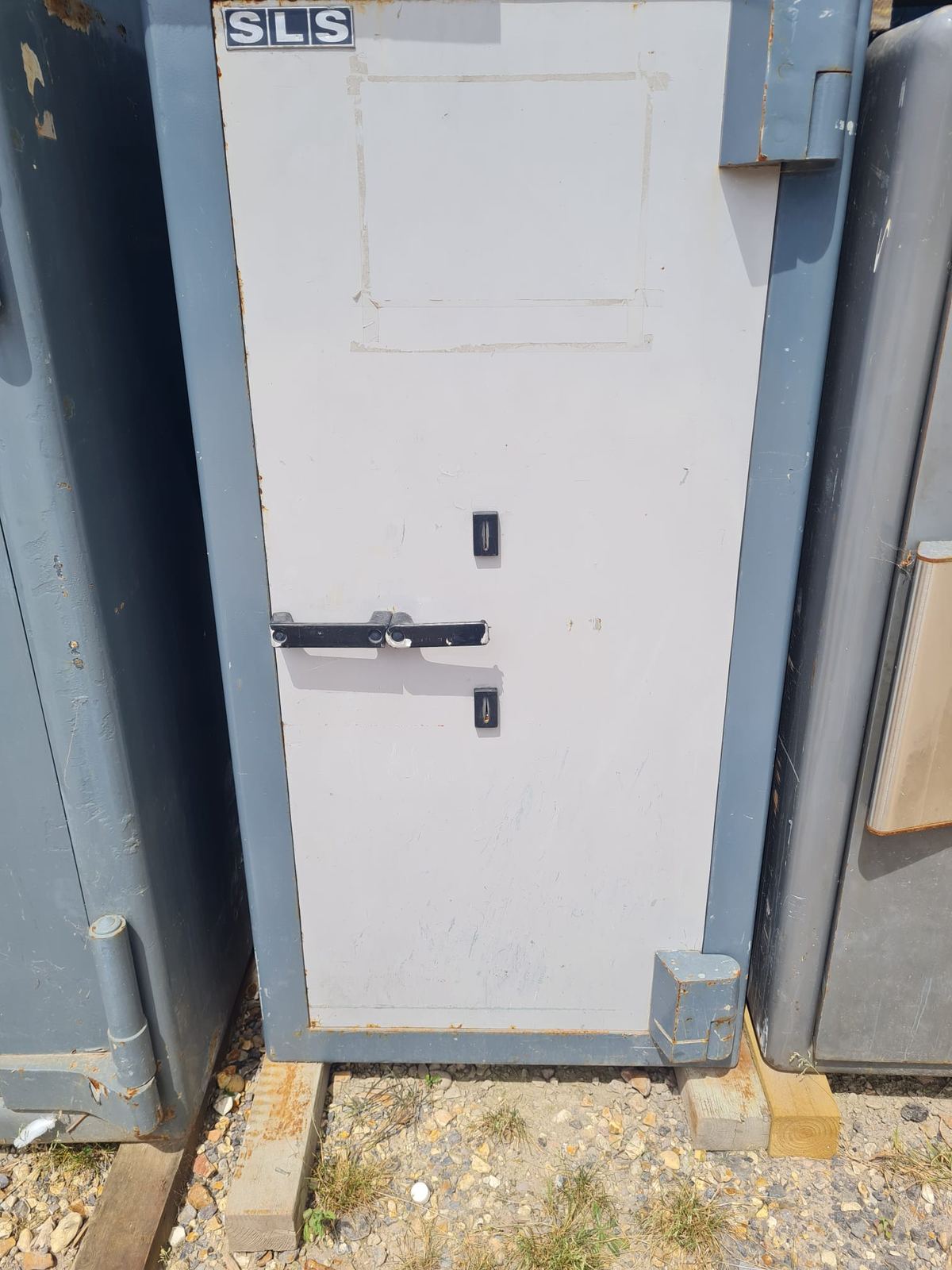 A high-security safe door with twin keyholes and a locking handle.
