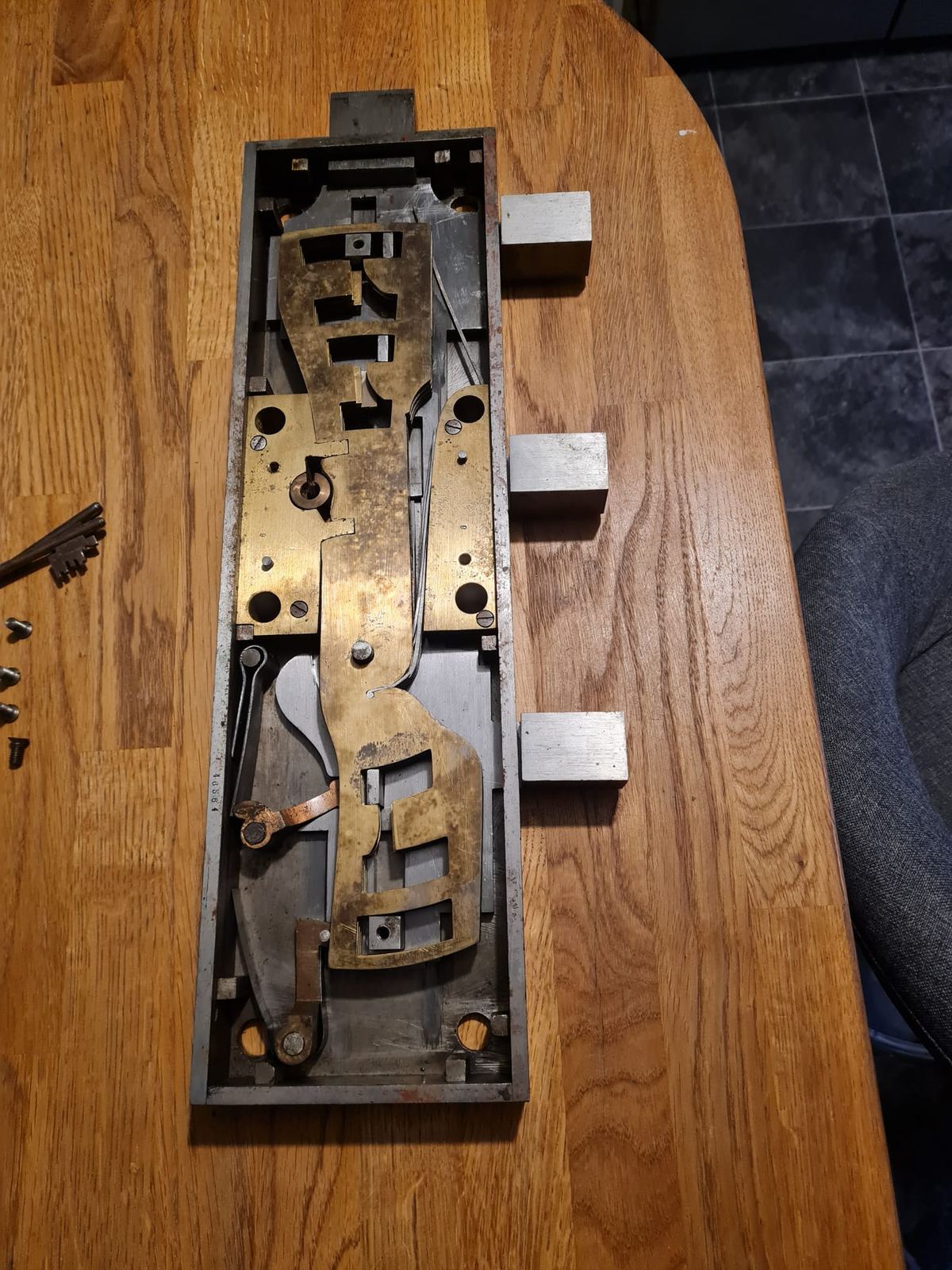 A vault lock case open on the workbench, showing the brass lever pack and boltwork.